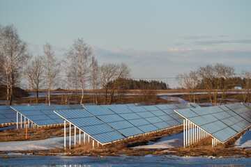 Solar panels stand in a row on the field. Alternative renewable green energy. Green energy technology for the future concept. Baltic states, Estonia.