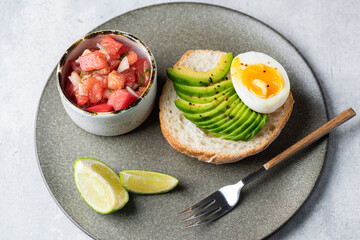 Toast with avocado, egg and tomatoes. Healthy breakfast or lunch meal