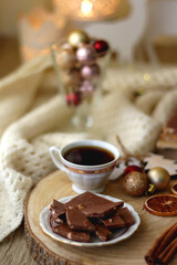 Cup of tea or coffee, various sweets and spices, Christmas decorations, comfy blanket, books and glasses. Selective focus.