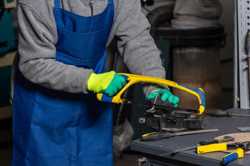 Worker is sawing in mechanical plant