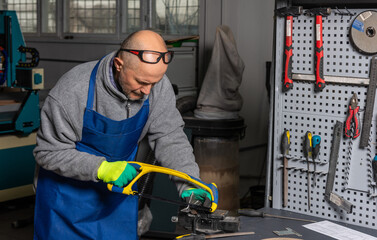 Worker is sawing in mechanical plant