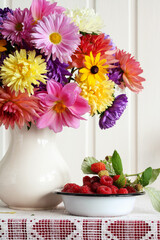 Obraz na płótnie Canvas Autumn bouquet and raspberries, garden flowers in a jug and berries.