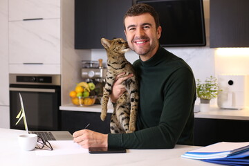 Attractive man working from home with his cat