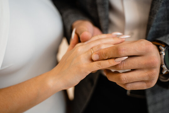 close-up of the hands, the groom put the ring on the bride