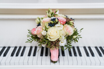 a magnificent wedding bouquet stands on the piano keys
