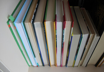 Books in a hard cover are arranged with a book block towards the viewer