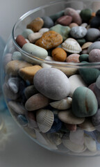 Variety Sea Stones With Quartz Veins Mixed With Shells In A Round Glass Vase
