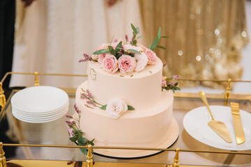 delicate wedding cake decorated with flowers on a trolley