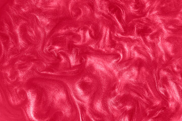 Red paint background. Motion of the pink shiny liquid. Color of the year 2023 Viva Magenta. Waves on a glittering liquid.