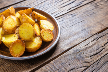 Fried potato wedges on a dark wooden background