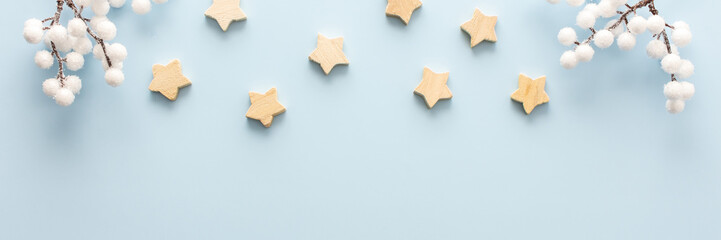 Natural wooden stars and rowan branches on a blue background, Christmas background, Merry Christmas and Happy New Year banner, top view, copy space