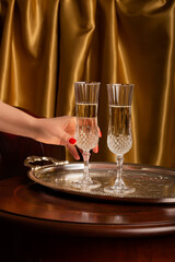 woman holding a crystal glass of champagne in her hands