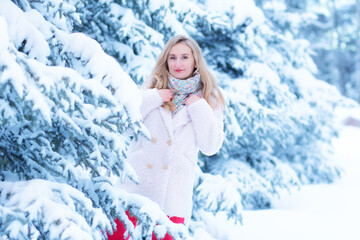 Fototapeta na wymiar Beautiful woman among white snowy trees in the forest.