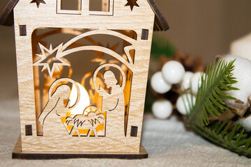 Nativity scene on a hill in the snow. Joseph of Nazareth lights the lantern and Mary tends to her baby, Jesus