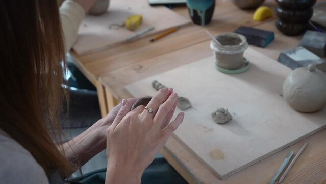 Woman's hands sculpt from a clay. Pottery workshop class. 