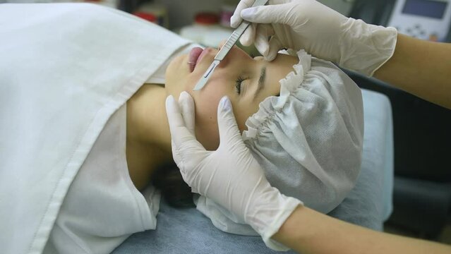 skin treatment with the dermaplaning technique performed with a scalpel by a beautician in a center of aesthetics and beauty of the body and skin