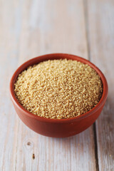 Dry couscous in a small ceramic bowl