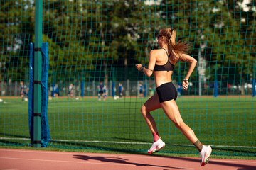 young fitness woman runner running on stadium track