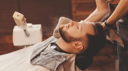 Vaporizer for face man in barbershop. Beard softening steam in preparation for shaving razor,...