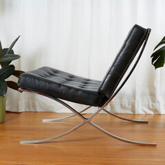 Black leather chair with chrome metal frame. Vintage reproduction furniture. Side view in a room...