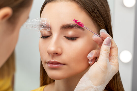 The make-up artist does Long-lasting styling of the eyebrows of the eyebrows and will color the eyebrows. Eyebrow lamination. Professional make-up and face care.