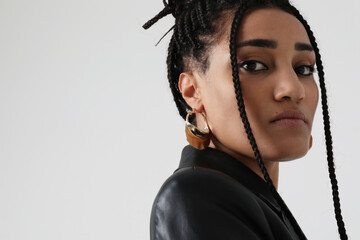 African American young woman with long dark braids, posing indoor. Mock-up.