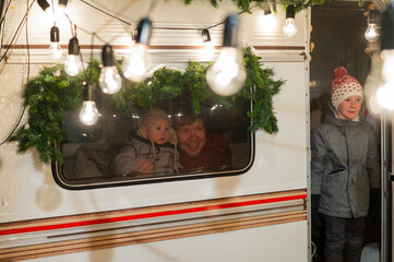 Father and two sons celebrate Christmas in a van.