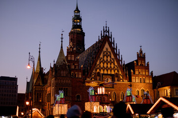 Naklejka premium Old church. Evening in Poland. Wroclaw. Christmas fair in the Poland. old town. Christmas lights. 