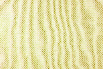 Fototapeta premium Close up background of knitted wool fabric made of viscose yarn. Pastel yellow color wool knitwear texture. Abstract knitted jersey background. Fabric abstract backdrop, wallpaper