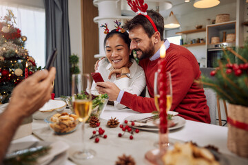 Family connecting with their loved ones over a video call during Christmas eve dinner