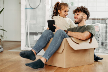 Father and daughter having fun in new apartment