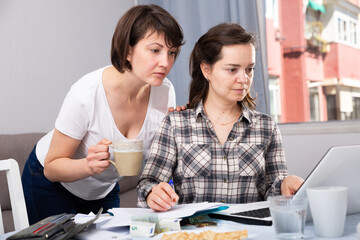 Obraz premium Women working with documents while working at laptop at home interior