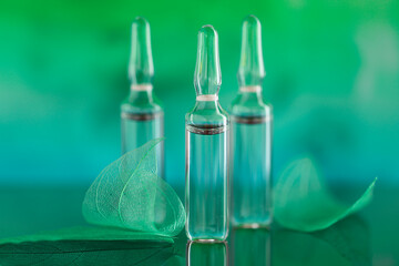  ampoules set and green skeletonized leaves on a turquoise blurred background.Mesotherapy and...