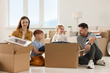 Happy family unpacking boxes in new apartment. Moving day