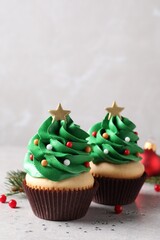 Christmas tree shaped cupcakes on light grey table