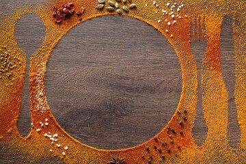 Silhouettes of cutlery and plate made with spices on wooden table, flat lay. Space for text