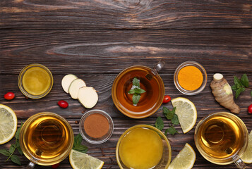 Flat lay composition of tea with honey and ingredients on wooden table. Space for text