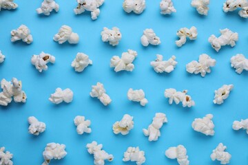 Tasty popcorn on light blue background, flat lay
