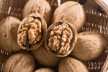 Walnut kernels and whole walnuts on wooden table.