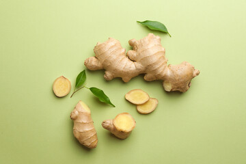 Fresh ginger with leaves on light pale green background, flat lay