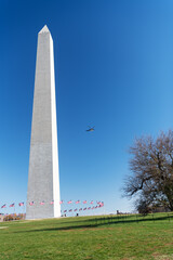 washington dc. A helicopter flies over George Washington's monument on a sunny day with a blue cloudless sky background.