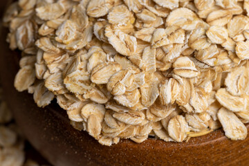 Oat flakes poured into a wooden bowl