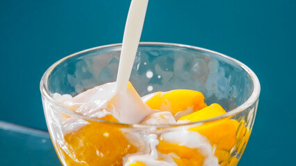 マンゴーに注がれる牛乳　デザートイメージ