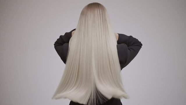 Luxurious long blonde hair in motion. Back view.