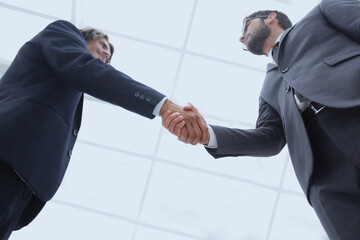 bottom view of two men shaking hands while standing