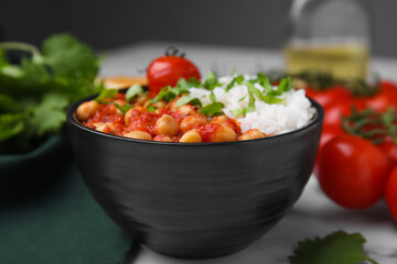 Delicious chickpea curry with rice in bowl on table, closeup