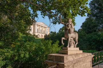 Fototapeta premium Centaur Bridge in Pavlovsky Park against the background of the Pavlovsky Palace on a sunny summer day, garden and park reserve in St. Petersburg, Russia