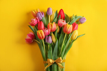 Bunch of beautiful tulips on yellow background, top view