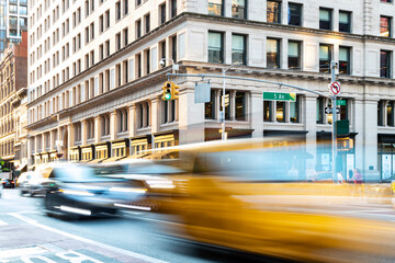 Yellow taxis and cars driving down the congested streets of Midtown Manhattan in New York City with...
