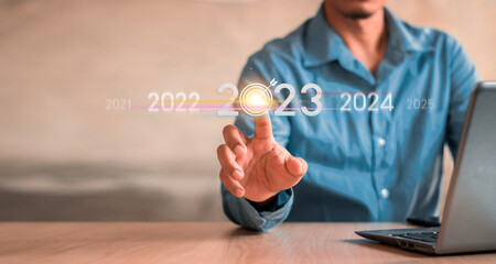 Businessman touch the glow light Data digital marketing graph and chart with arrow up.positive indicators in 2023, businessman calculates financial data for long-term investments.